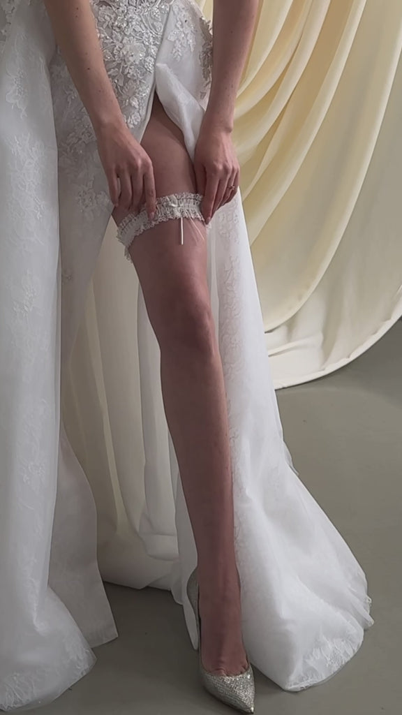 bride wears an ivory lace garter with satin bow detail
