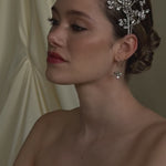 bride wears two stacked stilver crystal crowns and matching earrings