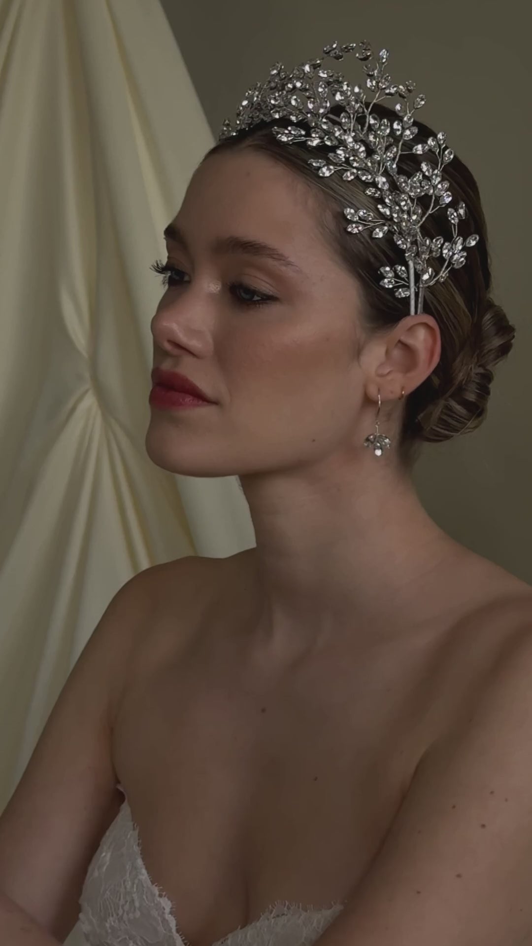 bride wears two stacked stilver crystal crowns and matching earrings