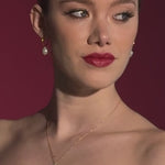 bride wears a lace mask style micro veilw with gold hoop baroque pearl earrings and matching necklace