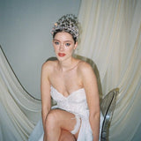 a bride wears a set of two stacked silver crystal crowns with matching hair pins extending over the top of her head s if growing from the tiara style base.