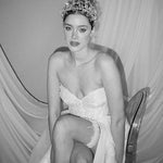 a bride wears a set of two stacked silver crystal crowns with matching hair pins extending over the top of her head s if growing from the tiara style base.