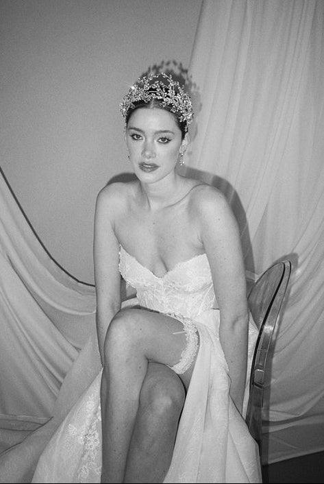a bride wears a set of two stacked silver crystal crowns with matching hair pins extending over the top of her head s if growing from the tiara style base.