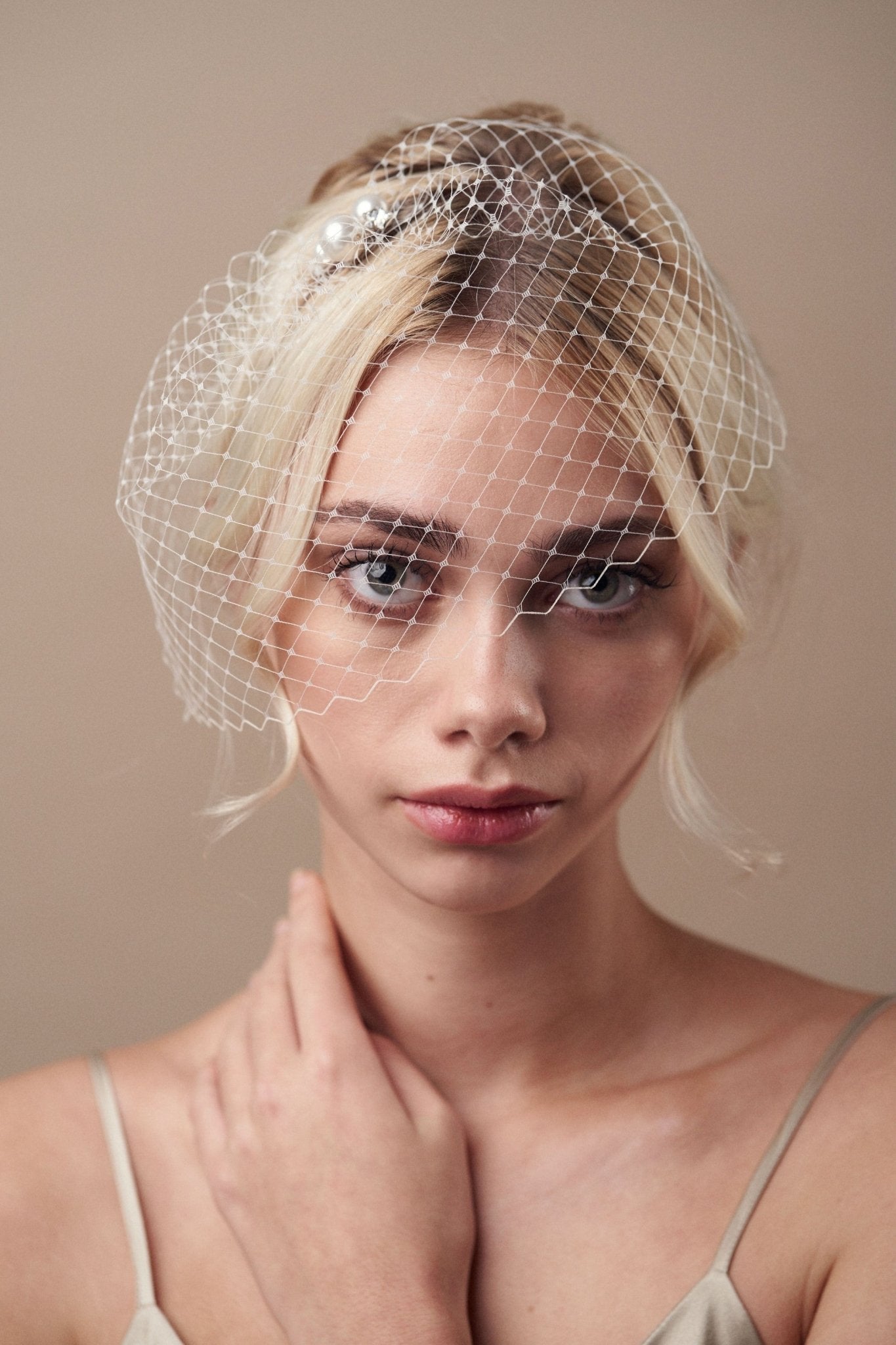 Short birdcage veil styled with pearl and star hairpin