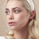 Ivory padded headband with adjustable birdcage veil attached worn covering the mouth