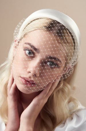 Ivory padded headband with adjustable birdcage veil attached worn covering the mouth