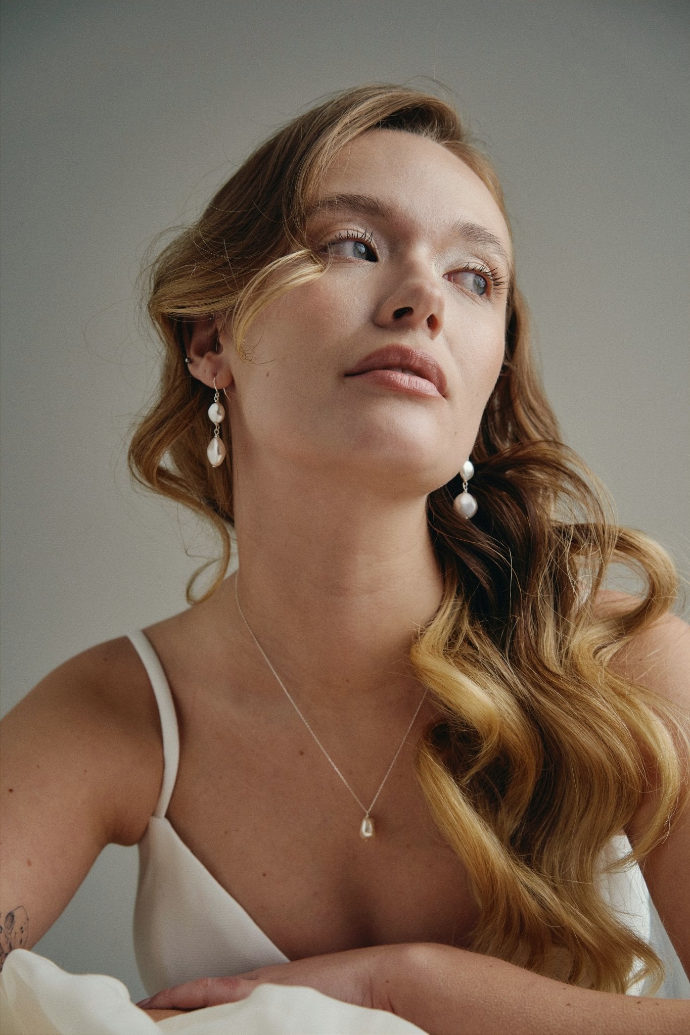 Model wears silver statement  vegan pearl drop earrings with matching vegan baroque pearl necklace