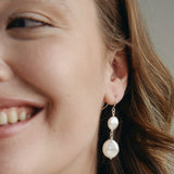 Model wears silver statement  vegan pearl drop earrings