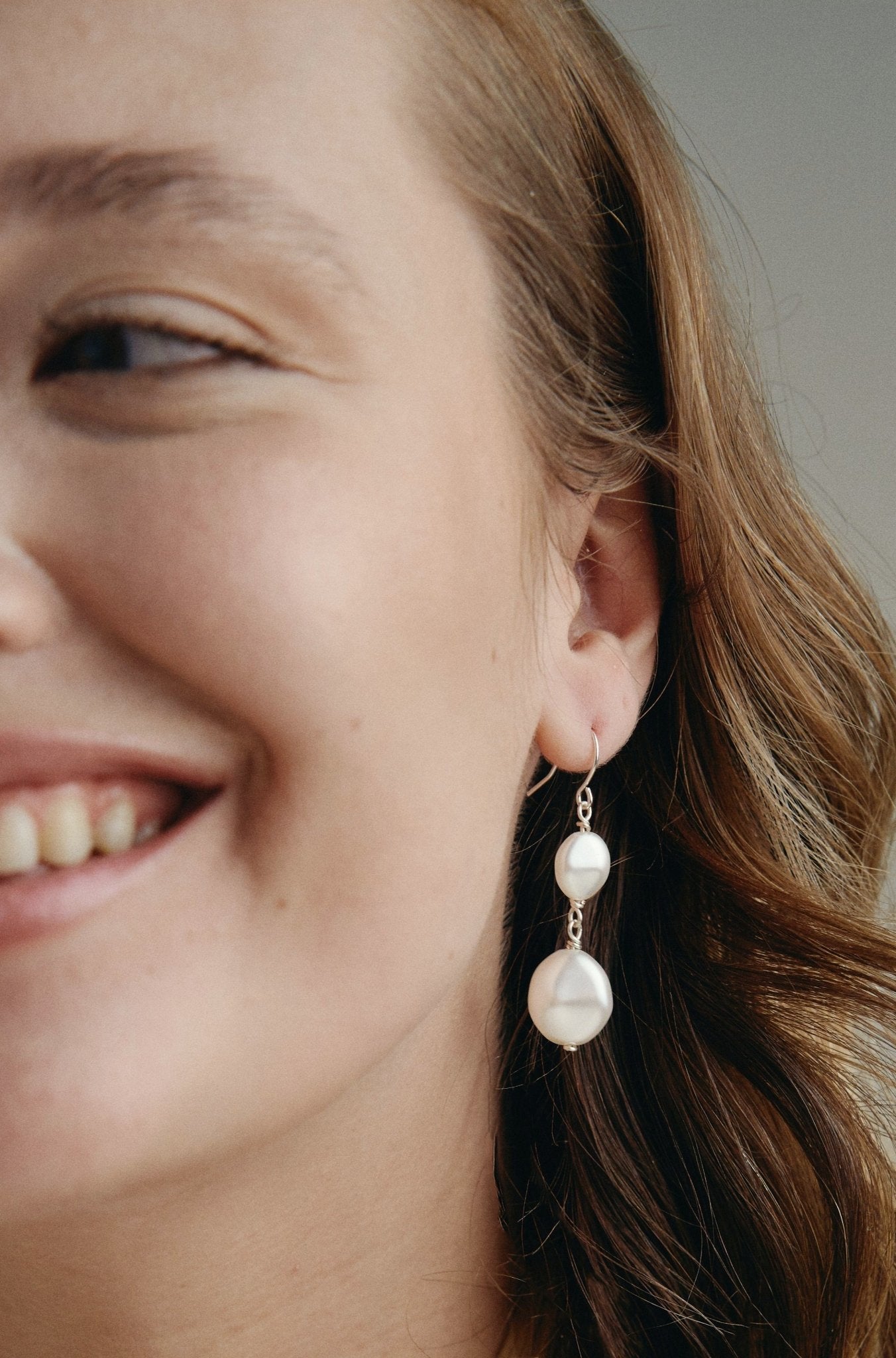 Model wears silver statement  vegan pearl drop earrings