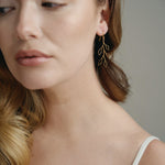 delicate gold wire leaf design earrings