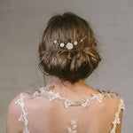 Rustic comb worn above a low bun with ivory flowers with gold crystals 