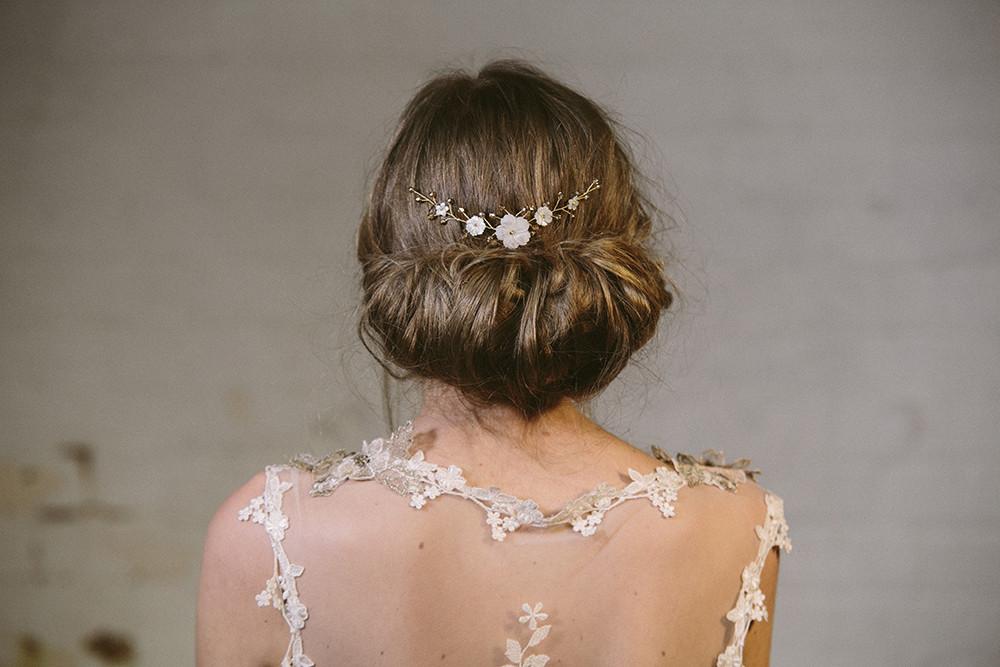 Rustic comb worn above a low bun with ivory flowers with gold crystals 